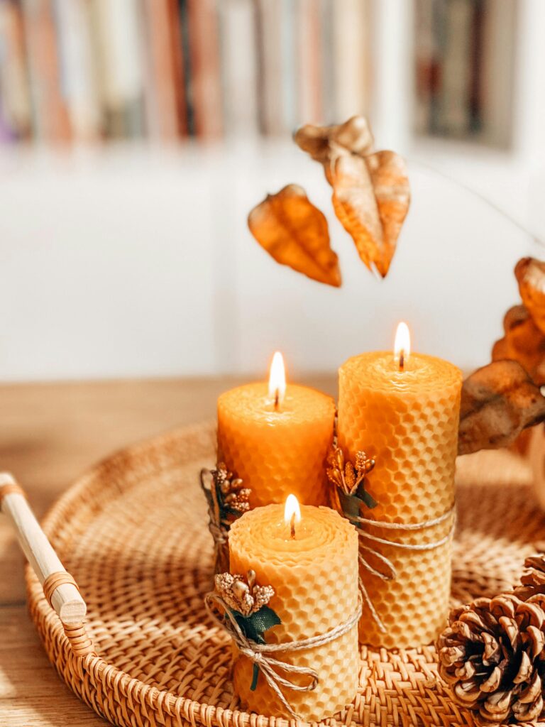 pexels-photo-10012665-10012665 Warm autumn scene with handmade beeswax candles on a wicker tray, evoking a cozy atmosphere.