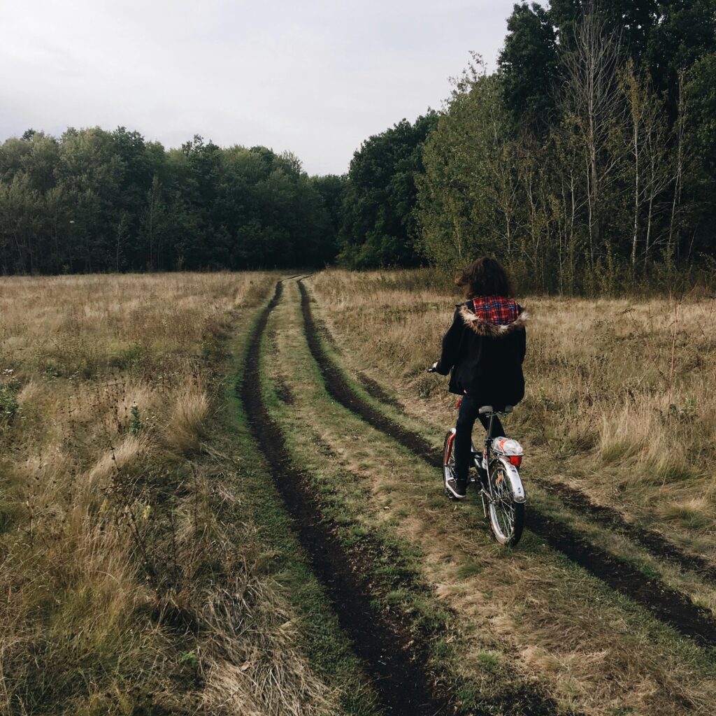 pexels-photo-11593579-11593579 A teenager riding a bicycle along a forest trail during autumn, showcasing nature and outdoor exploration.